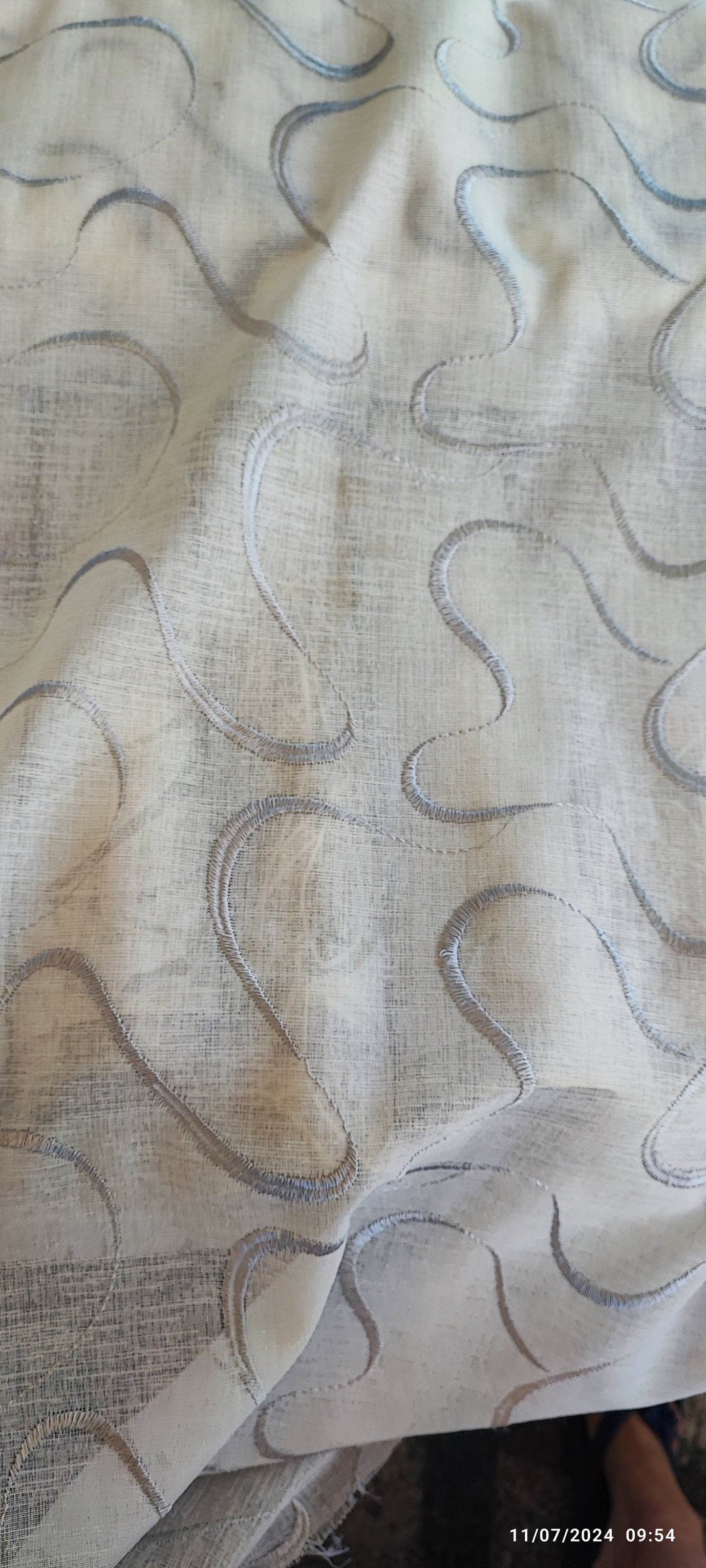 Glass curtain embroidered with waves in white, grey, beige and blue