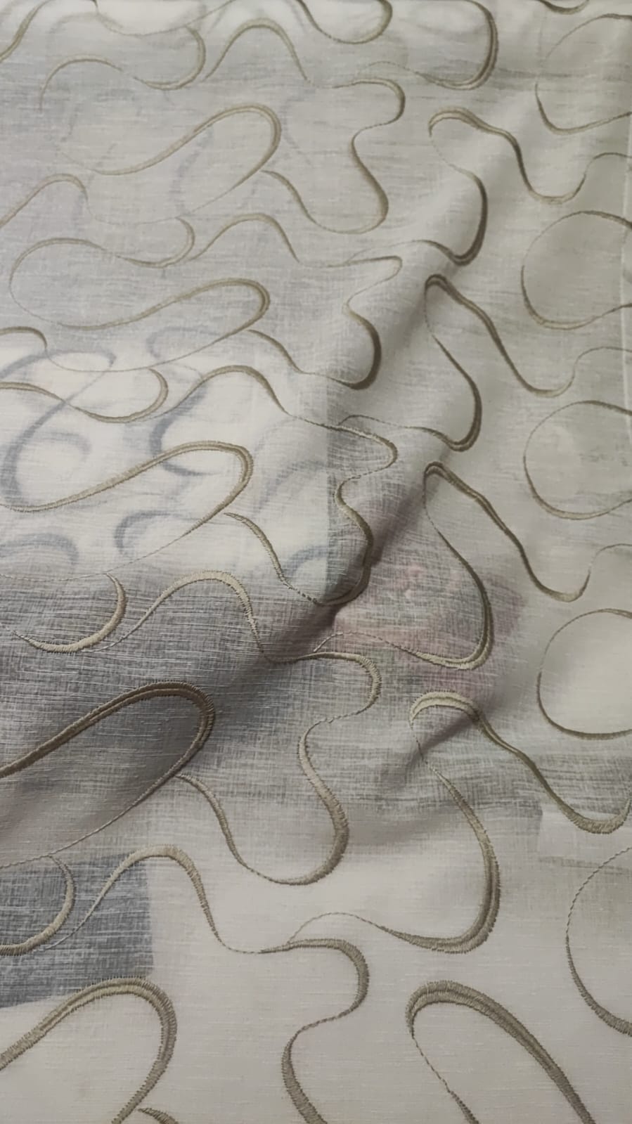 Glass curtain embroidered with waves in white, grey, beige and blue