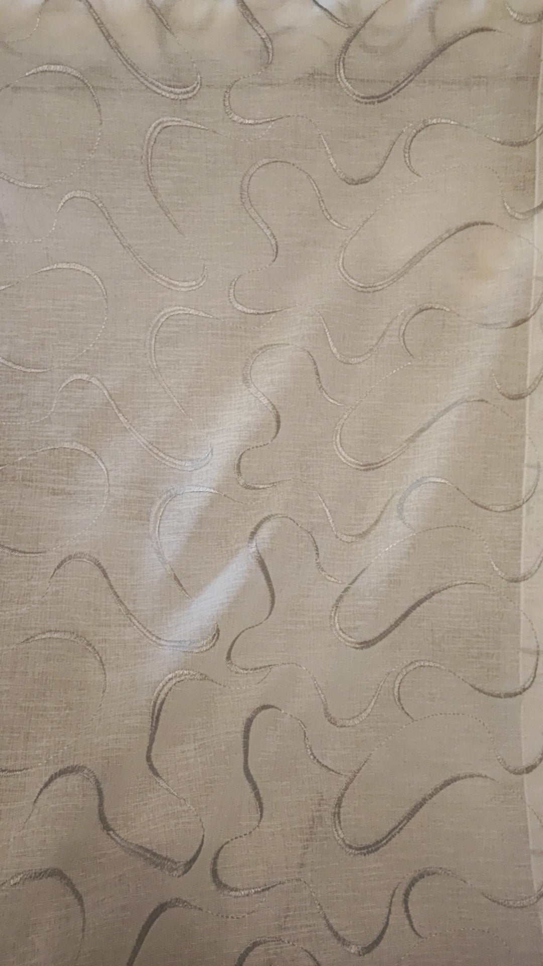 Glass curtain embroidered with waves in white, grey, beige and blue
